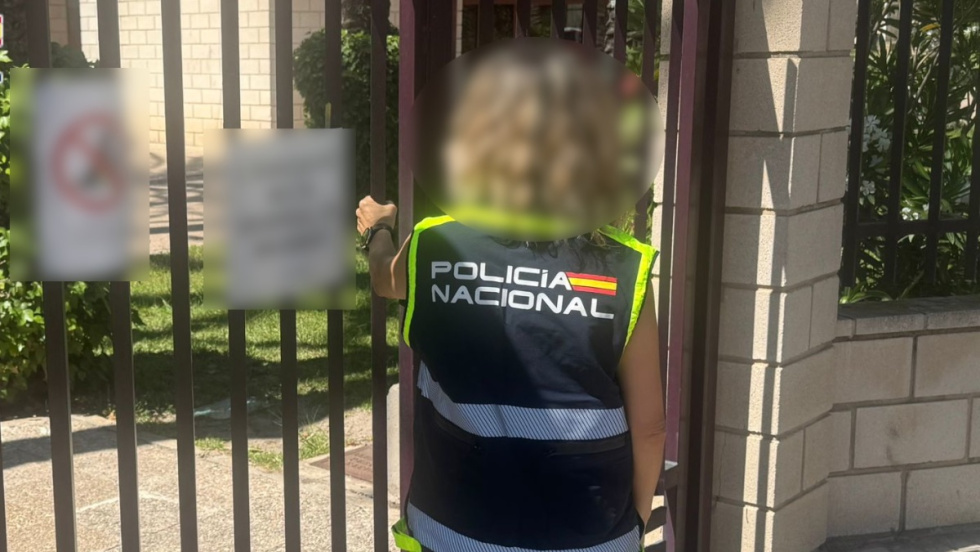 Agente de la Polic&iacute;a Nacional investiga en la puerta de una vivienda de Elche.