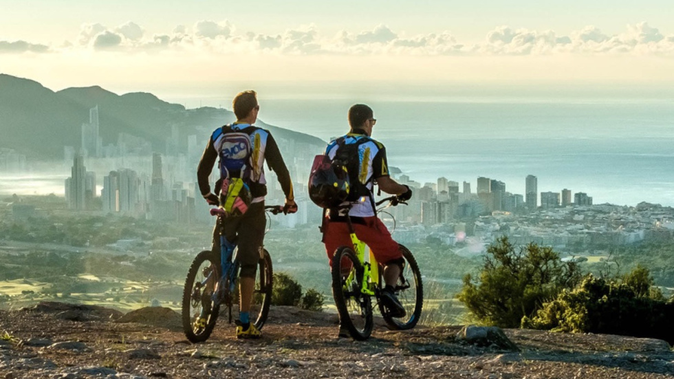 Dos ciclistas observan el skyline de Benidorm.