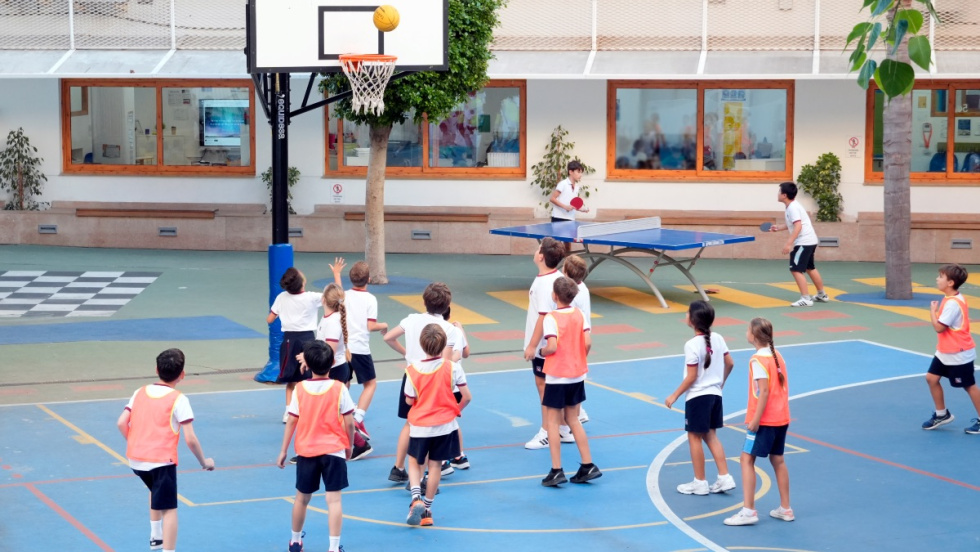Alumnos juegan al baloncesto.