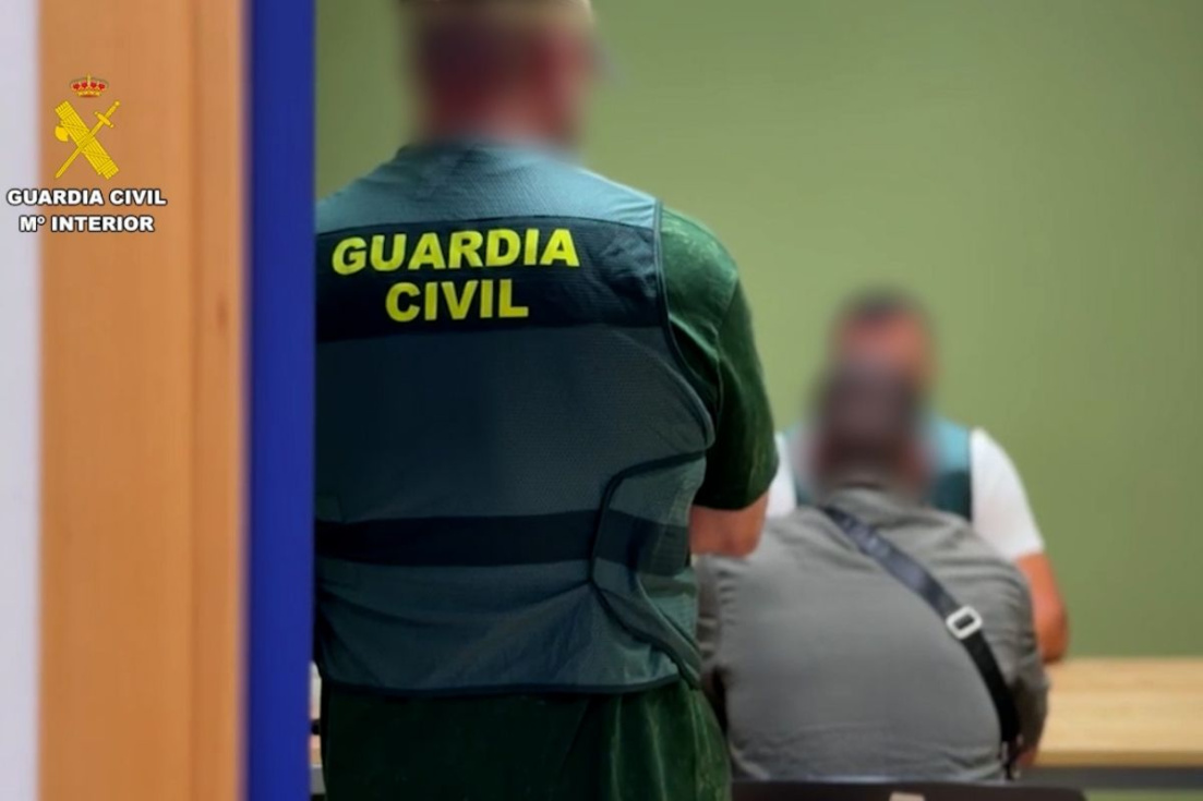 Agentes de la Guardia Civil junto a uno de los detenidos