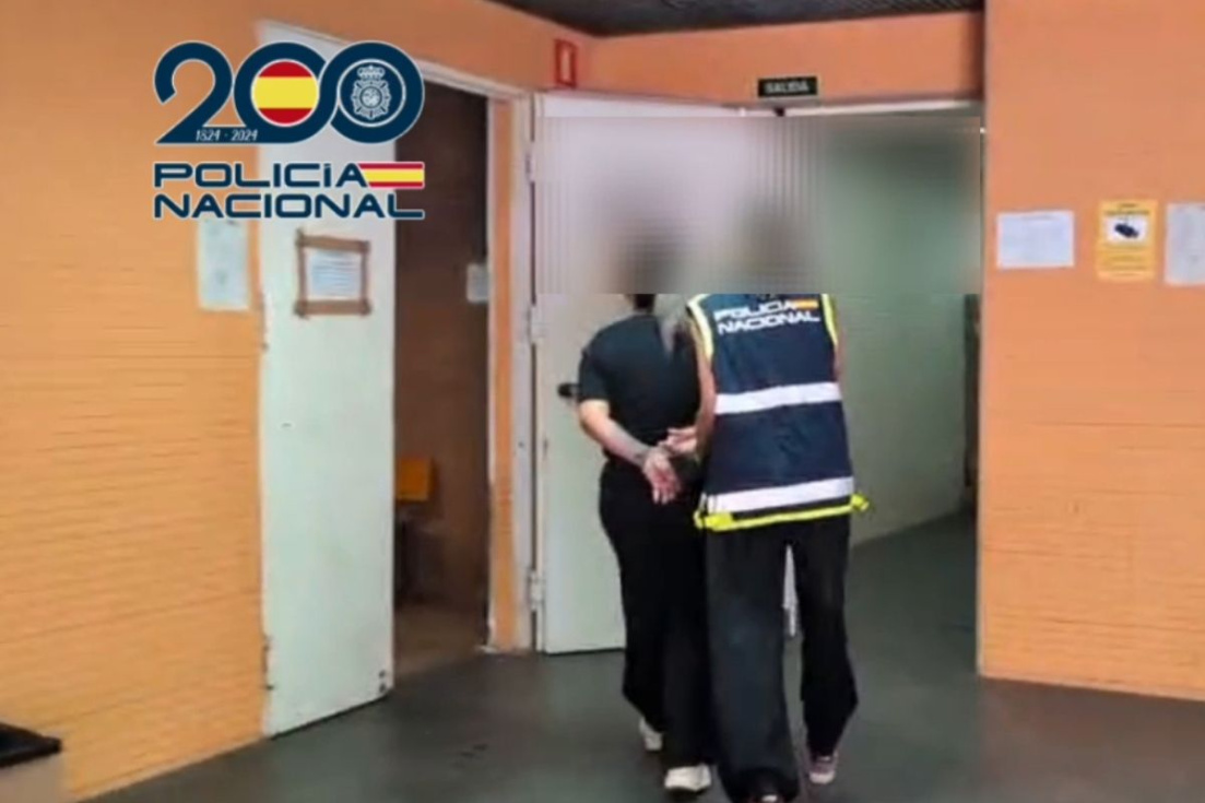 Una de las detenidas junto a una agente de la Polic&iacute;a Nacional